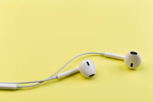 istock white earphones on yellow background 1129559952