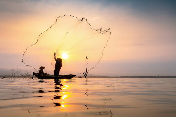 istock Fisherman on wooden boat. 1129560191