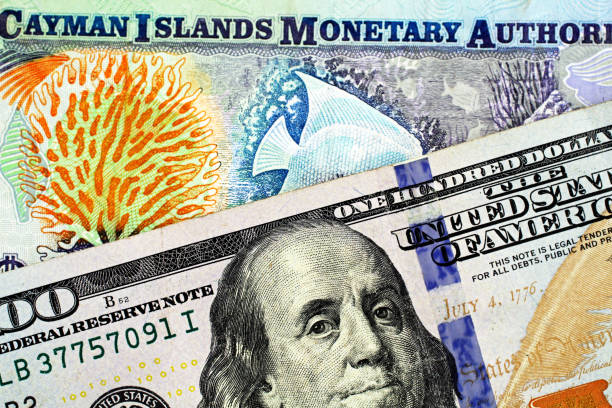 A colorful Cayman Islands dollar bill with an American one hundred dollar bill stock photo