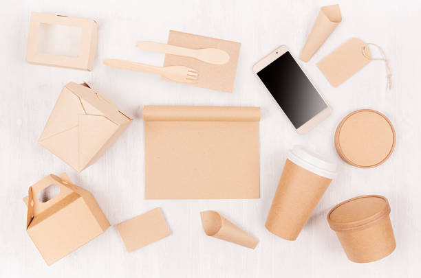 istock Food branding identity mockup in light modern style - blank screen phone,  cup, packet, box, label, card, container of brown paper  on white wood board. 1129563705