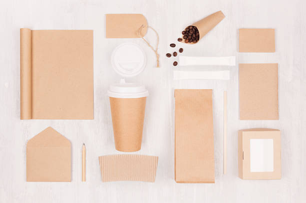 istock Coffee shop template for branding identity - brown paper cup, blank notebook, packet, label, card, box, stationery, coffee beans on white wood board. 1129563730