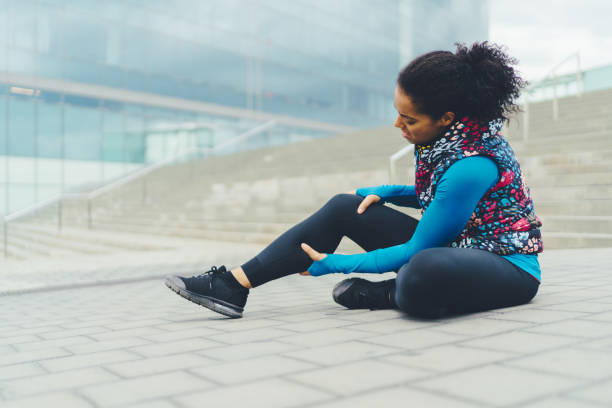 idrottskvinna med brutet ben sitter på marken, barcelona - runner holding legs bildbanksfoton och bilder