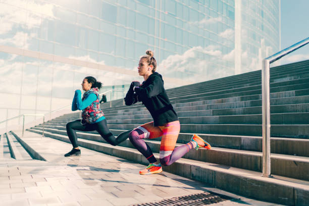 istock Girls doing frontal lunges at the steps outside 1129564156