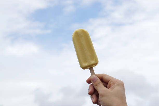 istock Hand holding durian ice cream bar on blue sky background and copy space. 1129565331