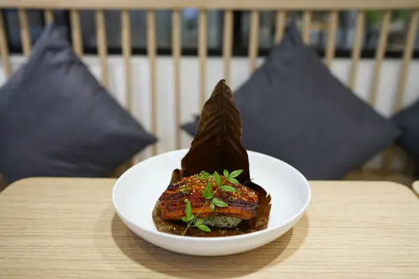 Photo of Unagi Donburi - Baked rice topped with grilled eel on a hoba leaf, Traditional Japanese Food.