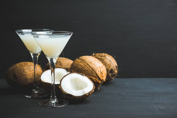 Sweet coconut cocktail in martini glass on the wooden background Sweet coconut cocktail in martini glass on the wooden background. Selective focus. Shallow depth of field. Gin stock pictures, royalty-free photos & images