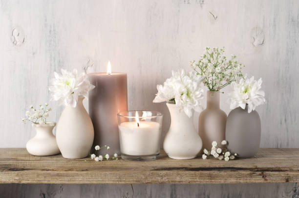 White flowers in neutral colored vases and candles