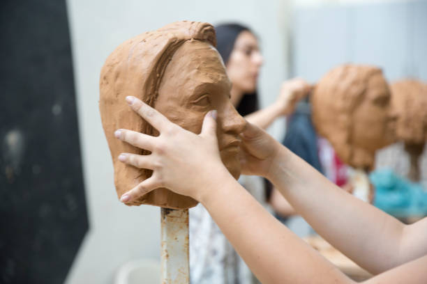 istock Artist working on clay sculpture in art studio 1129568000
