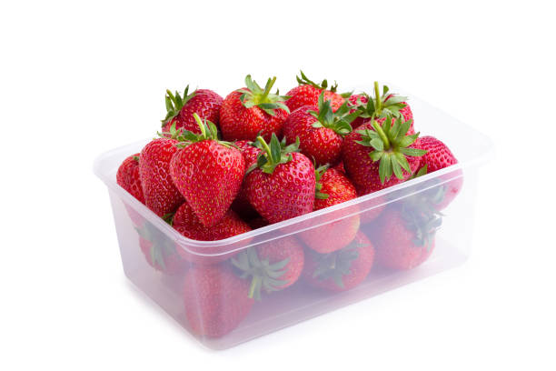 istock Fresh strawberries in a clear plastic box isolated over a white background 1129568083
