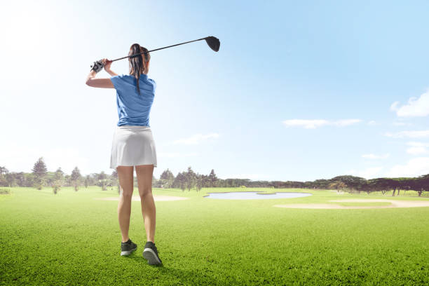 vista traseira da mulher asiática na longa viagem balanço com madeira club no campo de golfe com bunkers de areia, árvores e lagoa - golf swing golf golf club golf ball - fotografias e filmes do acervo