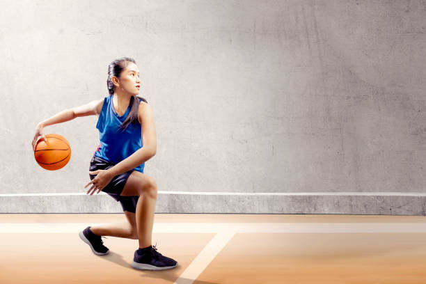 atractiva chica en uniforme en pivote de baloncesto azul deporte se mueve en la cancha de baloncesto - asian ethnicity philippines women beauty fotografías e imágenes de stock