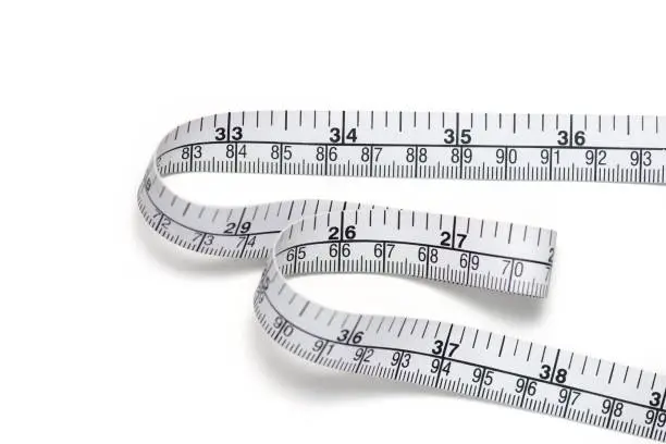 Close up tailor measuring tape on white table background, include clipping path. White measuring tape