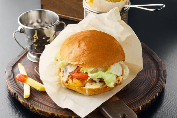 istock Tasty hamburger with fresh vegetables and fried potatoes. 1129571426