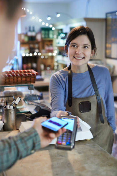 istock Male Customer Making Contactless Payment For Shopping Using Mobile Phone In Delicatessen 1129571698