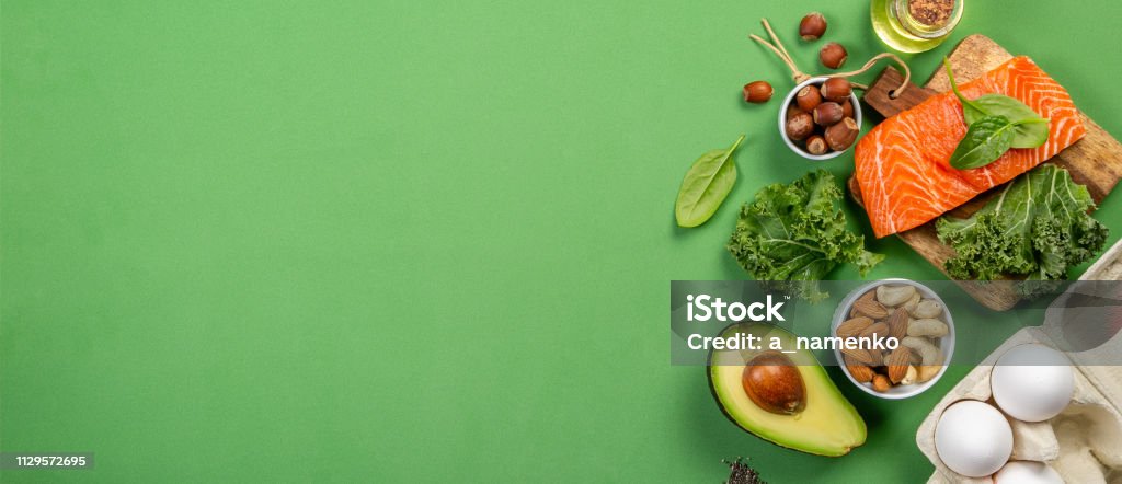 Keto diet concept - salmon, avocado, eggs, nuts and seeds Keto diet concept - salmon, avocado, eggs, nuts and seeds, bright green background, top view Healthy Eating Stock Photo