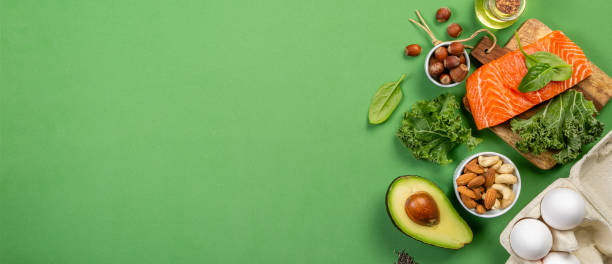 Keto diet concept - salmon, avocado, eggs, nuts and seeds Keto diet concept - salmon, avocado, eggs, nuts and seeds, bright green background, top view fat nutrient photos stock pictures, royalty-free photos & images
