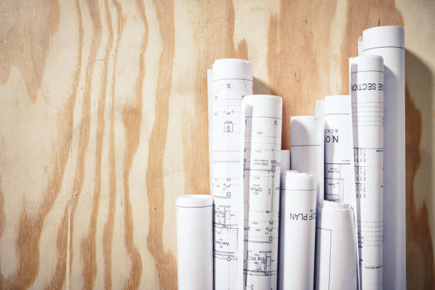 istock Blueprints rolled up and arranged on wooden surface 1129574060