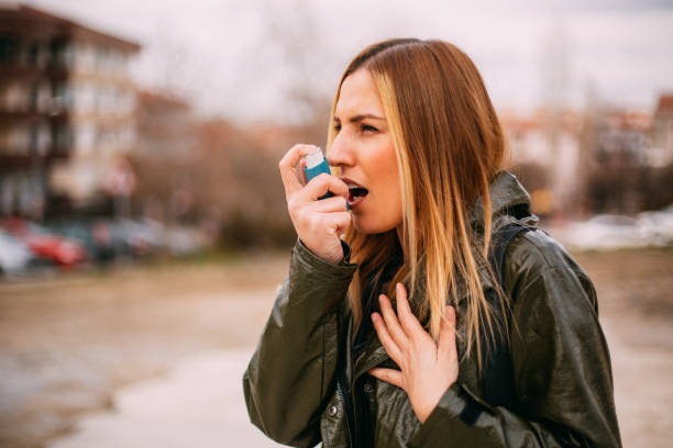 istock Young Blonde Woman Using an Asthma Inhaler 1129574188