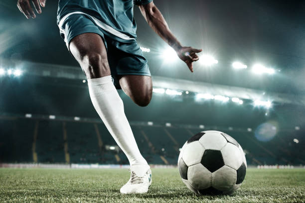 gambe di calciatore che calciano la palla - calciare foto e immagini stock