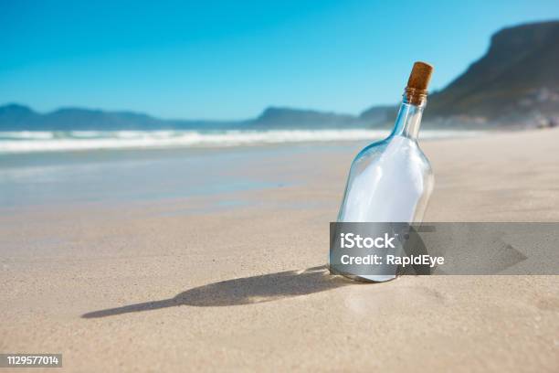 Bottle Propped Up On Sandy Beach Contains Blank Note Stock Photo - Download Image Now