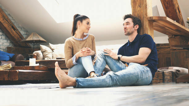 istock happy couple talking to each other at home 1129579277