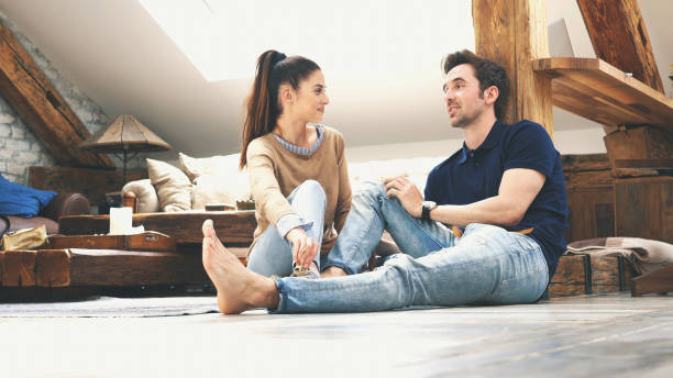 istock happy couple talking to each other at home 1129579356