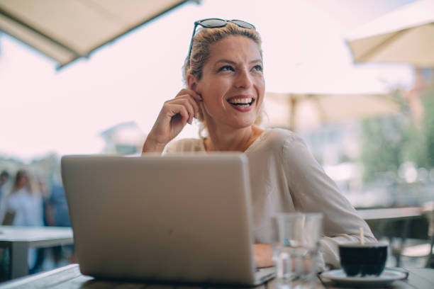 istock Charming woman using laptop in cafe 1129579739