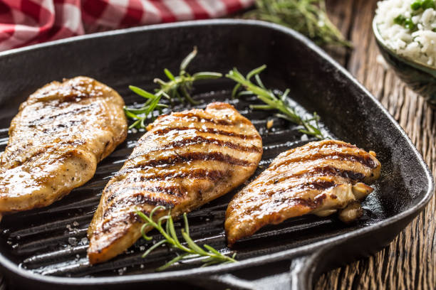istock Grilled chicken breast in grill pan with herbs. 1129580382
