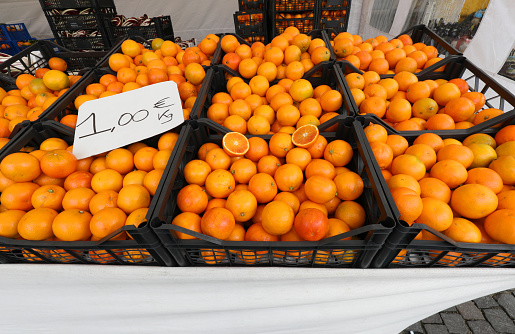 boxes full of ripe oranges for sale at supermarket with label price