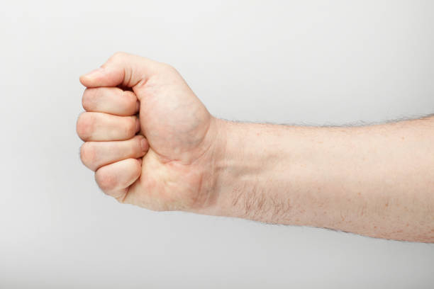 istock Male hand makes a fist, isolated  on the white background. 1129582305