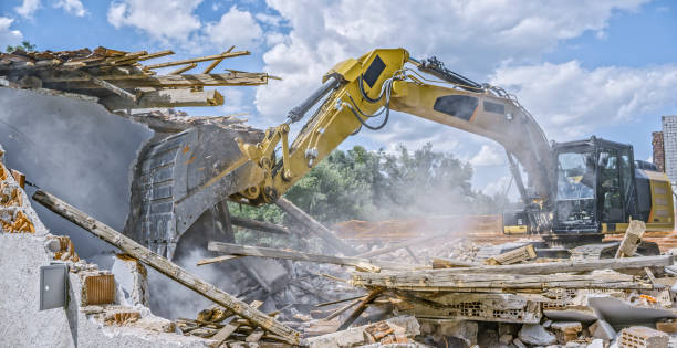 istock Digger tipping over outer walls of building being demolished 1129582625