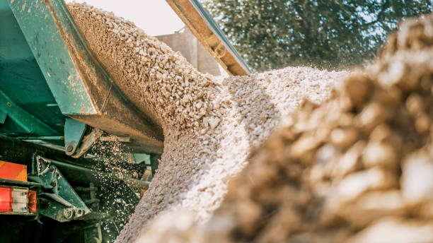 Gravel falling of digger at construction site Gravel being unloaded from bucket of digger at construction site. gravel stock pictures, royalty-free photos & images