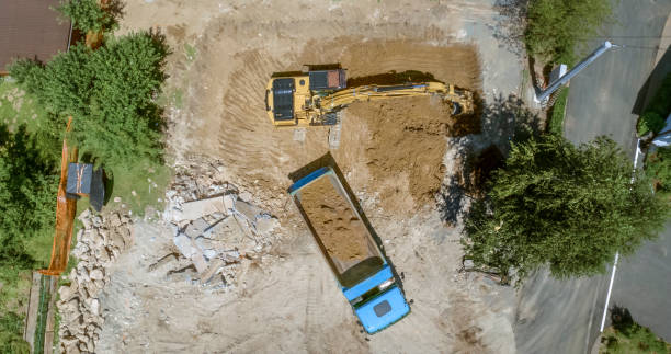 istock Excavator loading dug out soil onto truck at building site 1129582661