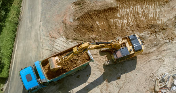 istock Excavator loading dug out soil onto truck at building site 1129582679