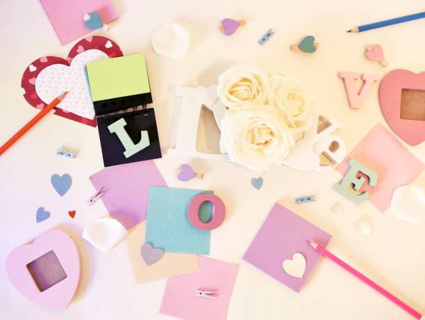 istock Decorative composition of volumetric letters, decor, roses, notebook, pencils on a light background 1129583510
