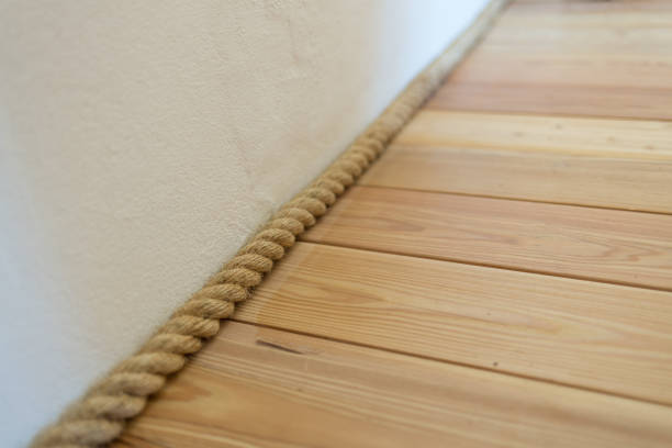 Empty white wall background with wooden floor lit with three small spot lights.