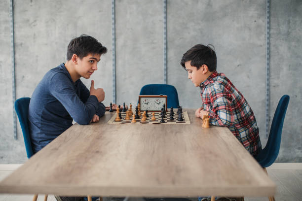 istock Two smart boys playing chess in school of chess 1129585010