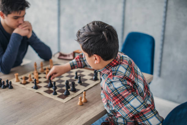 istock Boys playing chess in school of chess 1129585214