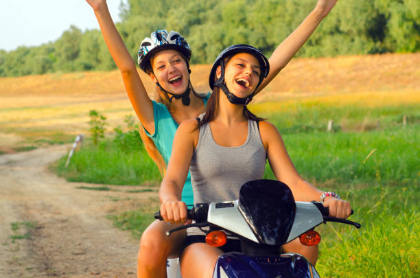 istock Young women riding motor scooter 1129589435