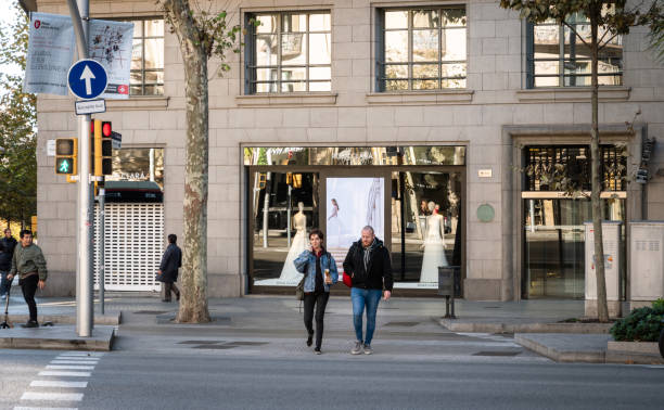 Avinguda Diagonal with Rosa Clara luxury fashionable Barcelona, Spain - Nov 12, 2017: Couple pedestrians crossing street Avinguda Diagonal with Rosa Clara luxury wedding fashionable dress store in the background avenida diagonal stock pictures, royalty-free photos & images