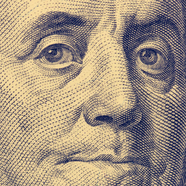 istock Fragment of hundred dollar bills. Franklin's face, square format, toned. 1129591842