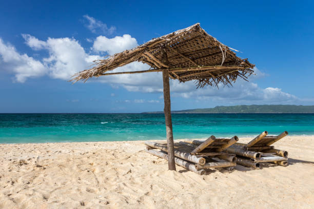 istock Sunbeds and umbrellas on a white sand beach 1129598880