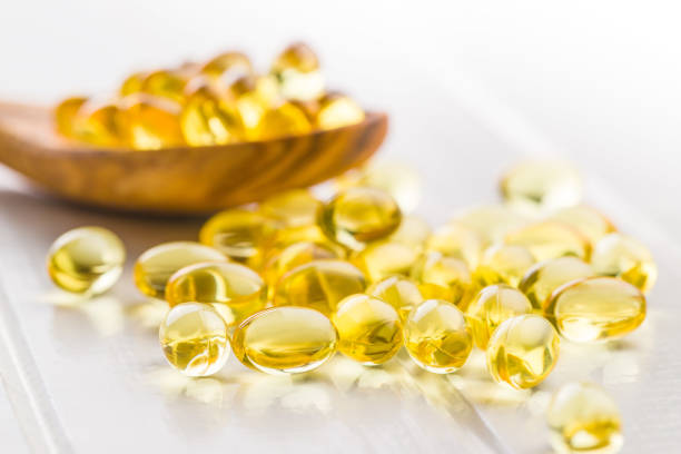 kapsułki żelowe omega 3. - cod liver oil fish oil capsule yellow zdjęcia i obrazy z banku zdjęć