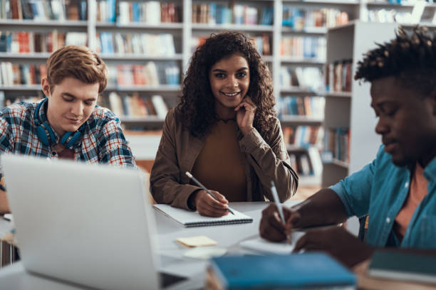 istock Pretty lady posing for photo while her friends studying 1129604917
