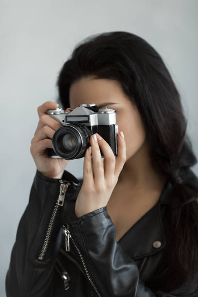 istock Beautiful young woman with camera 1129604959