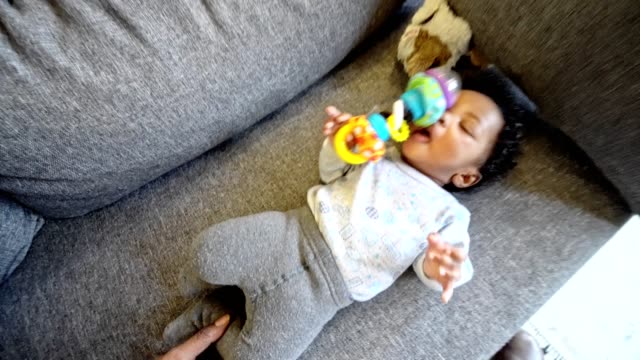 beautiful baby playing with toys on the couch