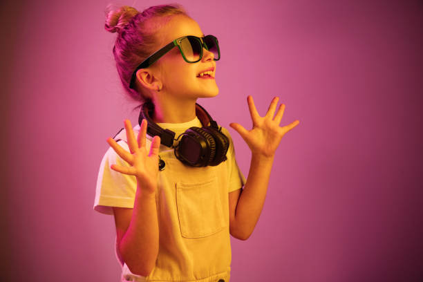Young girl with headphones enjoying music Neon portrait of young girl with headphones enjoying music. Lifestyle of young people, human emotions, childhood, happiness concept. dance  electronic music photos stock pictures, royalty-free photos & images