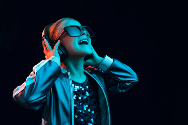 Young girl with headphones enjoying music Neon portrait of young girl with headphones enjoying music. Lifestyle of young people, human emotions, childhood, happiness concept. dance  electronic music photos stock pictures, royalty-free photos & images