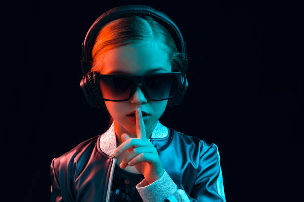 Young girl with headphones enjoying music Neon portrait of young girl with headphones enjoying music and calling for silence. Lifestyle of young people, human emotions, childhood, happiness concept. dance  electronic music photos stock pictures, royalty-free photos & images