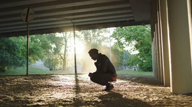 istock Loneliness metaphore. Young man sitting under bridge. Looking away 1129606858